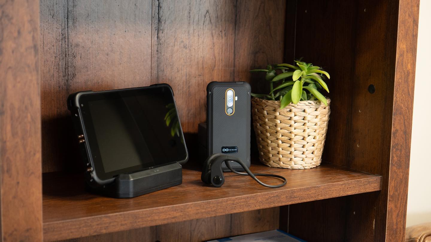 A tablet and phone on a wooden table.